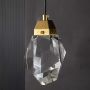 Detailed closeup of crystal pendant light highlighting its sharp facets and gold metal accent offering premium clarity and refined modern lighting style.