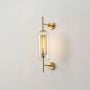 Elegant wall light with gold metal base and glass shade glowing warmly perfect for modern home interior lighting.
