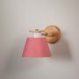 Modern wooden wall sconce with pink lampshade light off white background for bedroom kids room and hallway decorative wall lighting.