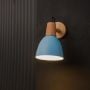 Wall light glowing with teal blue shade wooden base and black cord creating warm ambient lighting for modern interiors.