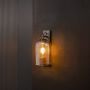 Wall light glowing with amber glass shade and black base creating warm ambient illumination for stylish home interiors.