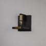 Black and gold wall light with metal frame and exposed bulb shown off on white background for modern interior wall decor.