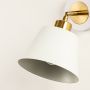 Closeup view of white and gold metal wall sconce highlighting its angled shade smooth finish and warm bulb design for modern decorative lighting decor.