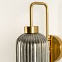 Closeup view of smoke grey ribbed glass wall sconce highlighting its detailed vertical texture and smooth metal frame suited for refined modern interior home decor lighting.
