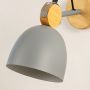 Grey metal wall light closeup showing smooth dome shade and wooden backplate detail for modern minimalist interior lighting decor.