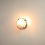 Small marble wall sconce glowing warmly on white background with gold metal brackets perfect for minimalist and refined home decor.