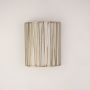 Gold cylindrical wall sconce displayed in natural room setting without white background for warm lighting ambiance.
