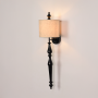 Lamp styled wall light on white background showing tall black metal body with soft fabric shade for clean modern product presentation.
