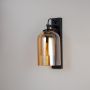 Wall sconce with amber glass shade and black base perfect for bedroom living room and hallway walls in modern interiors.