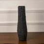 Black textured ceramic tumbler vase displayed on white background showcasing matte finish tactile surface and contemporary decor styling.