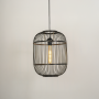 Oval black wire pendant light illuminated on white background showcasing modern aesthetic and warm inviting glow.