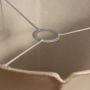 A detailed interior closeup view of a beige fabric lampshade showing the inner metal ring and support frame against a soft white background.