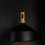 A black pendant light with a wooden top glowing softly against a dark background enhancing its warm light effect and modern sculpted form.