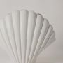 Closeup of white shell sculpture showing smooth ridged detailing and curved form for a refined coastal decor accent.
