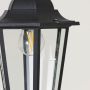 Closeup view of black hanging lantern showcasing detailed metal frame and clear glass panels.