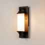 Black metal wall light with frosted glass glowing warmly on white background ideal for hallway or porch wall decor.