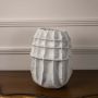White sculptural ceramic vase displayed on white background with ribbed geometric texture for minimalist modern decor accent.